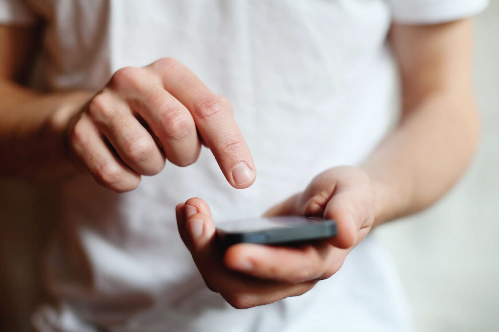 A person holding a cell phone in their hands.